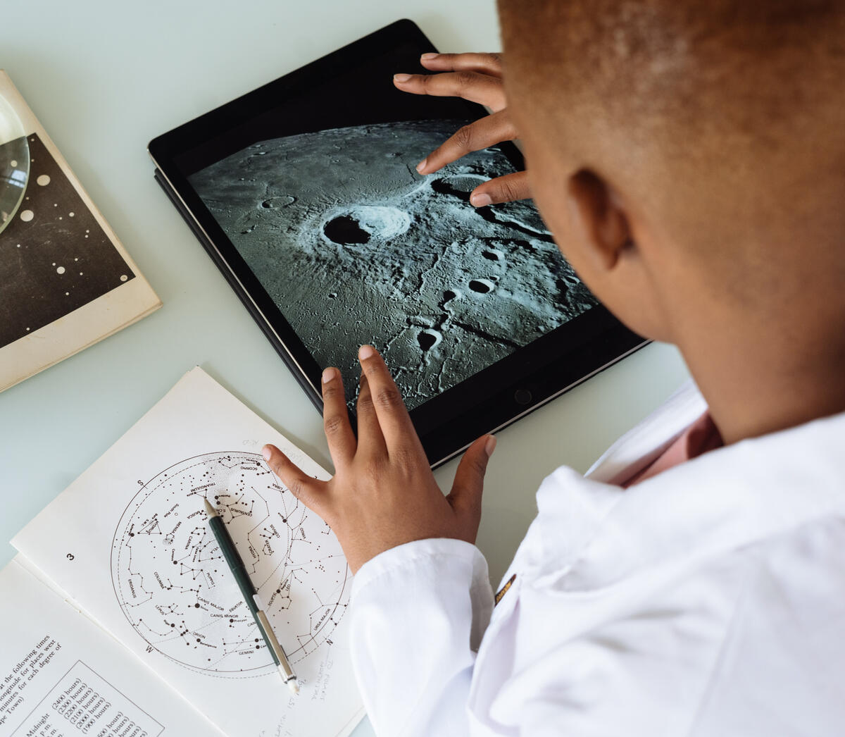 Photo by RF._.studio: https://www.pexels.com/photo/crop-african-american-student-studying-craters-of-moon-on-tablet-at-observatory-3825569/